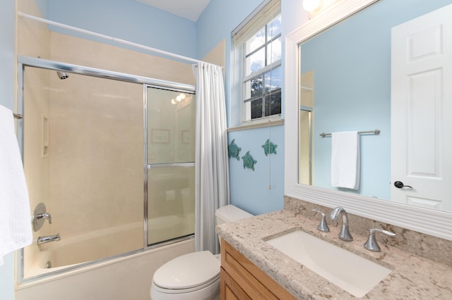 full bathroom featuring vanity, enclosed tub / shower combo, and toilet