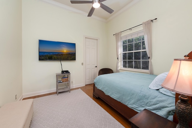 bedroom featuring wood-type flooring, crown molding, and ceiling fan