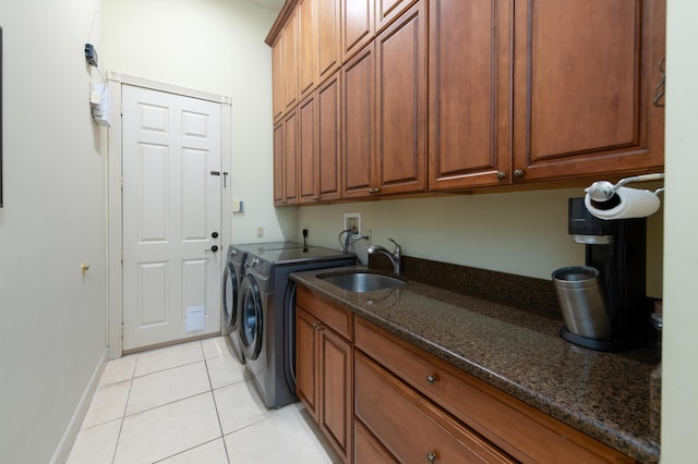 laundry room with light tile patterned flooring, cabinets, sink, and washing machine and clothes dryer