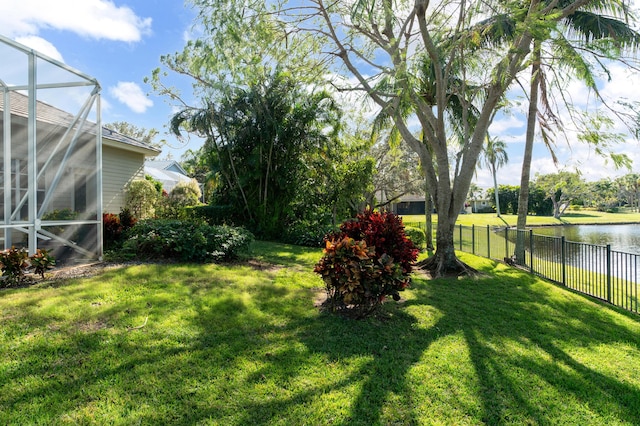 view of yard featuring a lanai and a water view