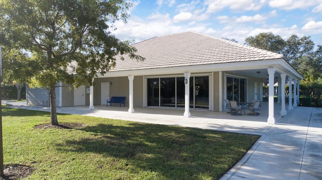 rear view of house with a patio, a yard, and a shed