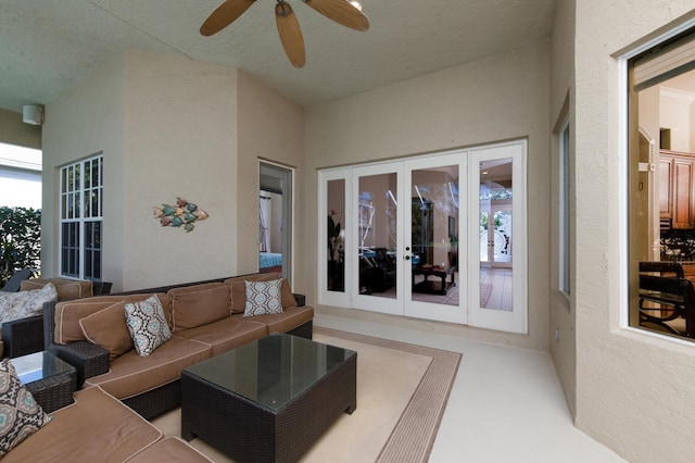 living room featuring ceiling fan, a textured ceiling, and french doors