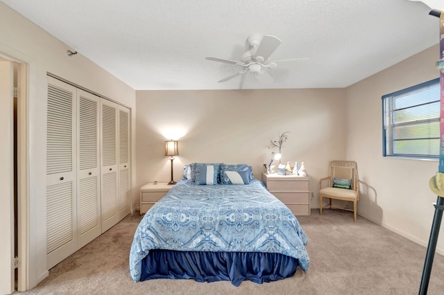 bedroom with ceiling fan, a closet, and light colored carpet