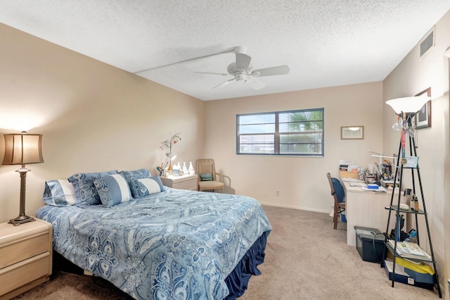 bedroom with a textured ceiling, light colored carpet, and ceiling fan