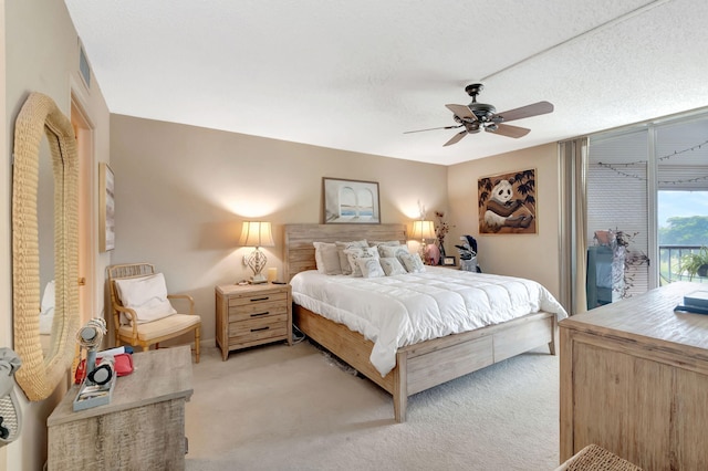 bedroom featuring light carpet, a textured ceiling, access to outside, and ceiling fan