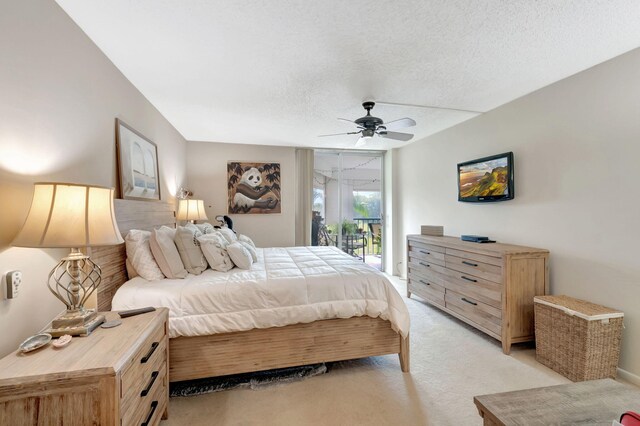 bedroom with access to exterior, ceiling fan, light colored carpet, and a textured ceiling