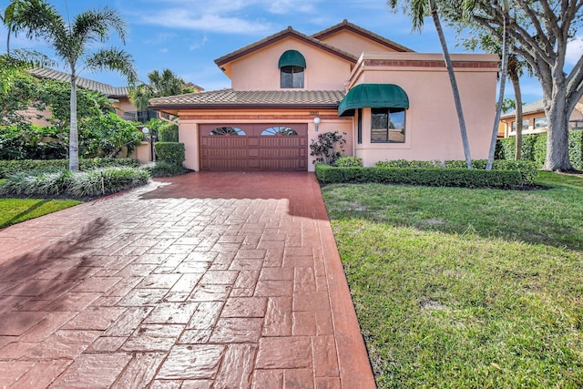 mediterranean / spanish home with a front yard and a garage