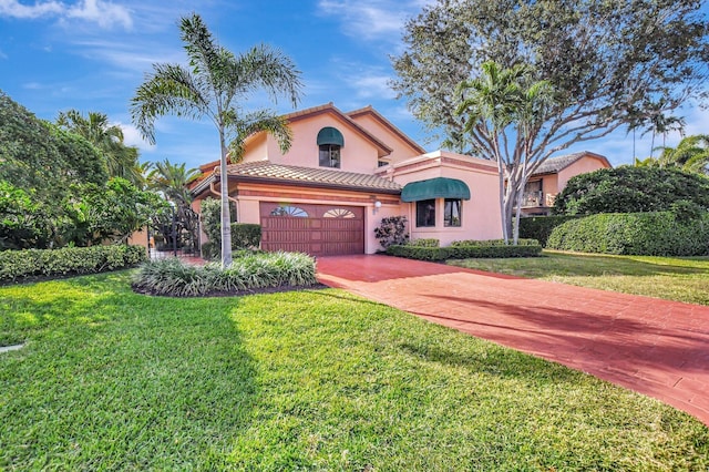 mediterranean / spanish home featuring a front yard and a garage