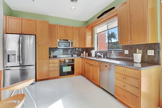 kitchen featuring black appliances, sink, dark stone countertops, and backsplash