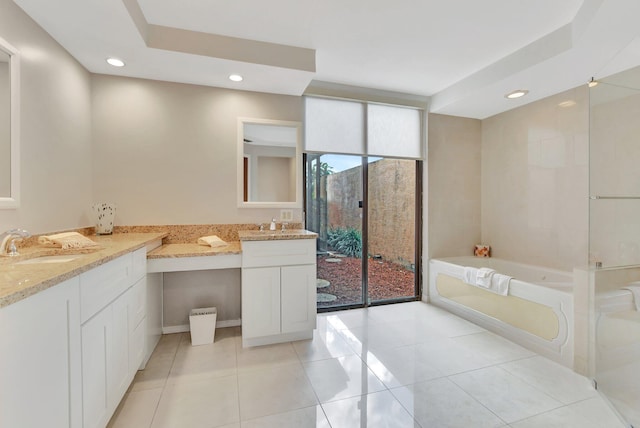 bathroom with a washtub, vanity, and tile patterned floors