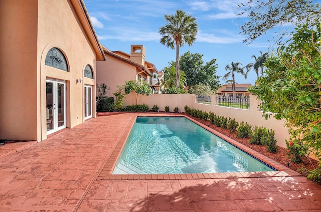 view of swimming pool with french doors and a patio