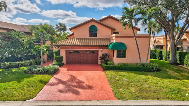 mediterranean / spanish home with a garage and a front lawn