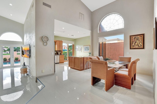 dining room with light tile patterned floors, high vaulted ceiling, and french doors