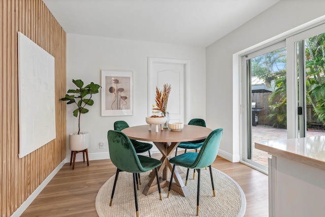 dining room featuring light wood finished floors and baseboards