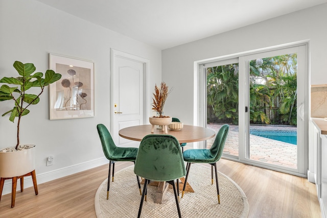 dining room with baseboards and light wood finished floors