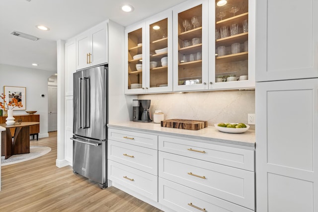 bar with recessed lighting, visible vents, high end fridge, light wood-type flooring, and tasteful backsplash