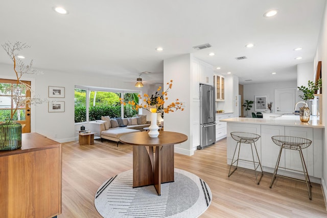 dining space with light wood-type flooring, baseboards, visible vents, and recessed lighting