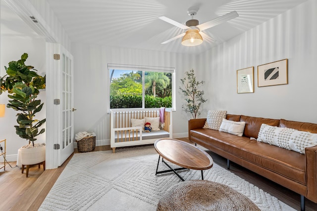 living room with french doors, ceiling fan, baseboards, and wood finished floors