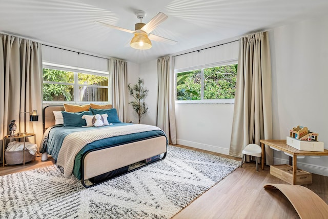 bedroom with ceiling fan, baseboards, and wood finished floors