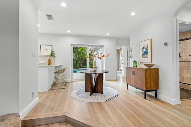 interior space featuring arched walkways, recessed lighting, visible vents, baseboards, and light wood-type flooring