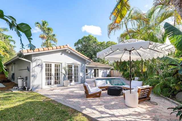 back of house featuring french doors, stucco siding, a patio area, fence, and an outdoor pool