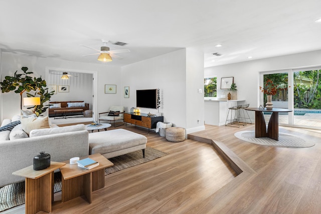 living area featuring a healthy amount of sunlight, visible vents, wood finished floors, and recessed lighting