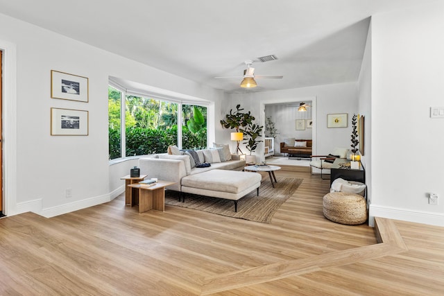 living room with baseboards, ceiling fan, visible vents, and wood finished floors