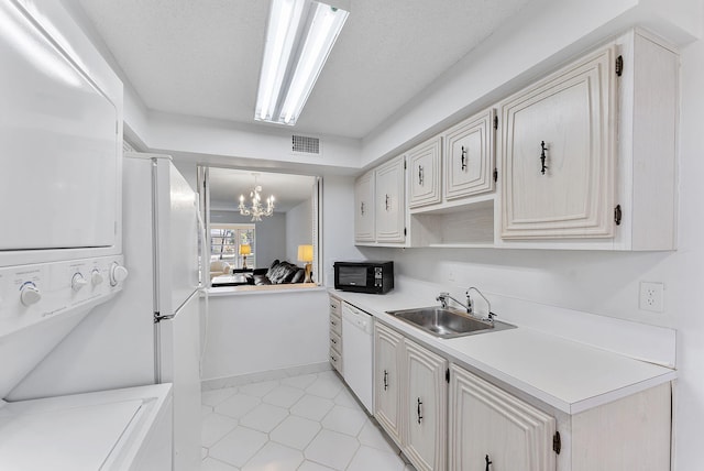 kitchen featuring dishwasher, sink, hanging light fixtures, an inviting chandelier, and a textured ceiling