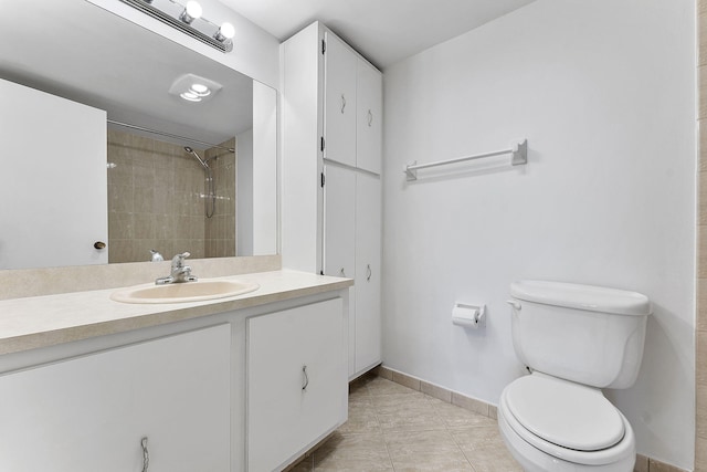 bathroom with tile patterned floors, vanity, toilet, and a tile shower