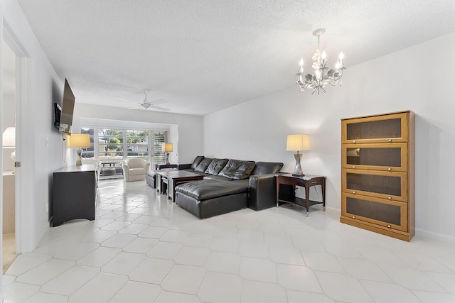 living room featuring ceiling fan with notable chandelier and a textured ceiling