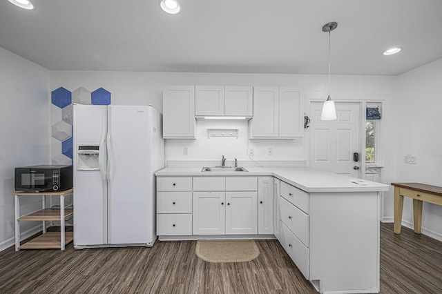 kitchen featuring sink, hanging light fixtures, dark hardwood / wood-style floors, white fridge with ice dispenser, and white cabinetry