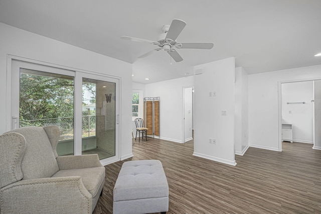 living area with ceiling fan and dark wood-type flooring