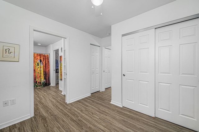 unfurnished bedroom with dark wood-type flooring and two closets