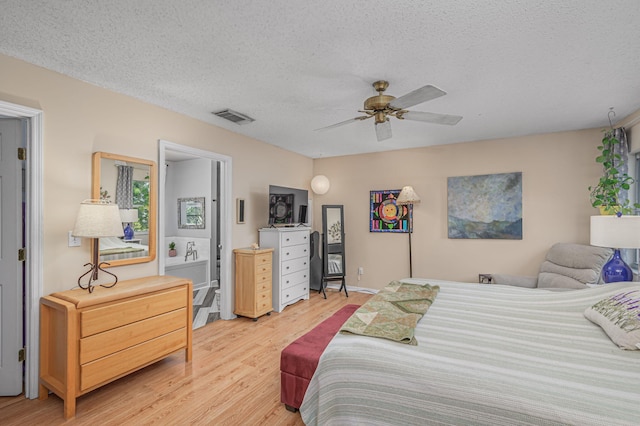 bedroom featuring ceiling fan, light hardwood / wood-style flooring, and a textured ceiling