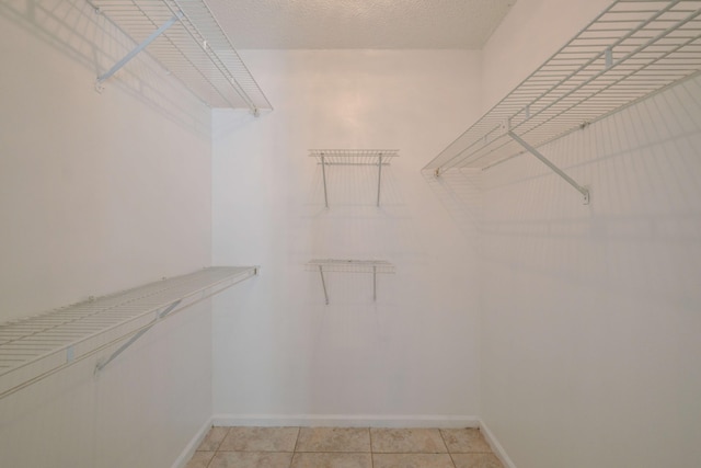 walk in closet with light tile patterned flooring