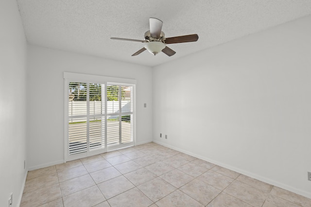 empty room featuring light tile patterned floors, a textured ceiling, and ceiling fan