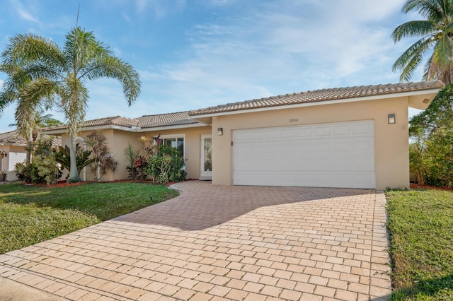 mediterranean / spanish home featuring a front yard and a garage