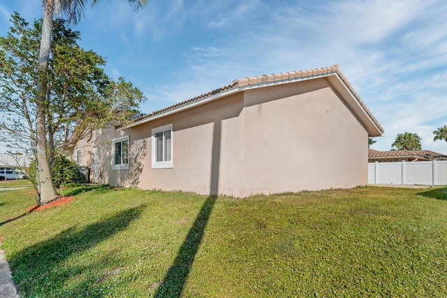 view of side of home with a yard