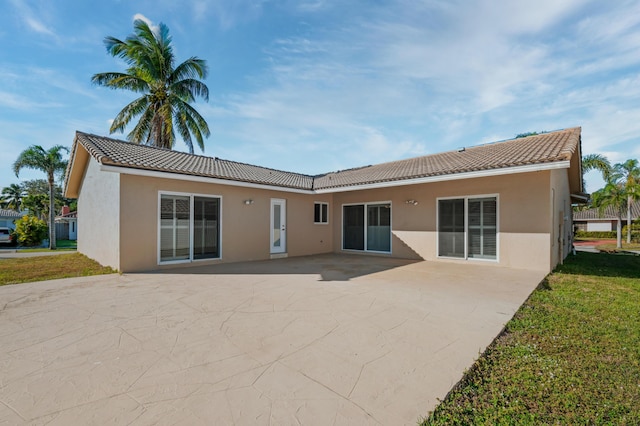 rear view of property featuring a yard and a patio