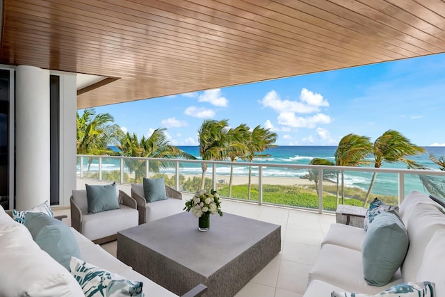 view of patio / terrace featuring outdoor lounge area, a water view, a beach view, and a balcony