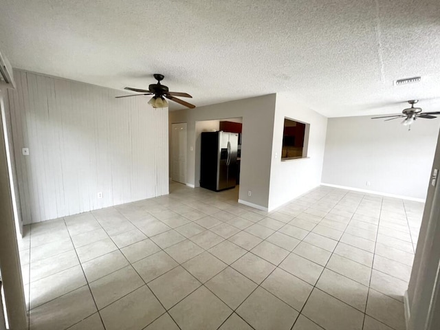 tiled spare room featuring ceiling fan and a textured ceiling