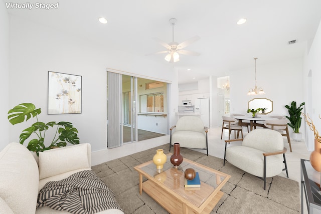 living room with ceiling fan with notable chandelier