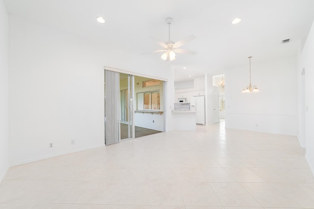 tiled empty room featuring ceiling fan with notable chandelier