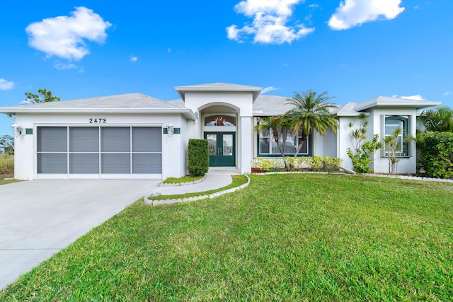 view of front of house featuring french doors, a front lawn, and a garage