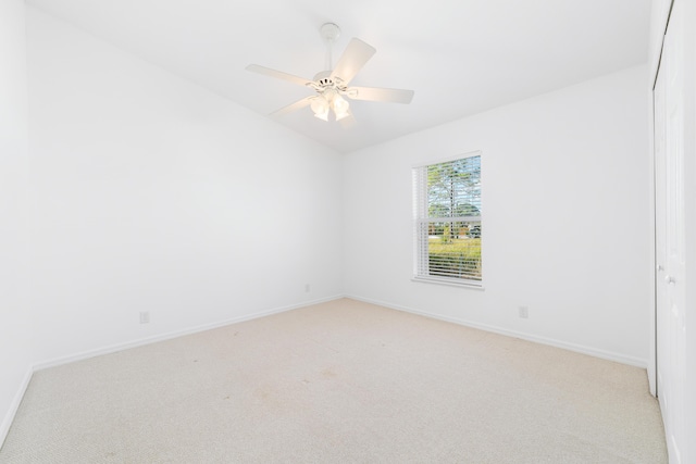 carpeted spare room with ceiling fan