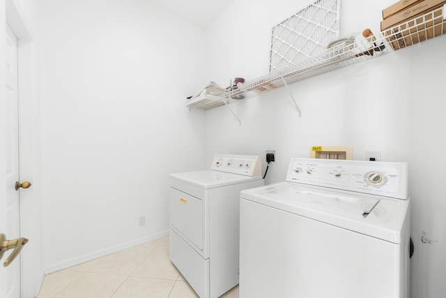 laundry area featuring washer and dryer and light tile patterned flooring