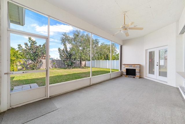 unfurnished sunroom with ceiling fan and french doors