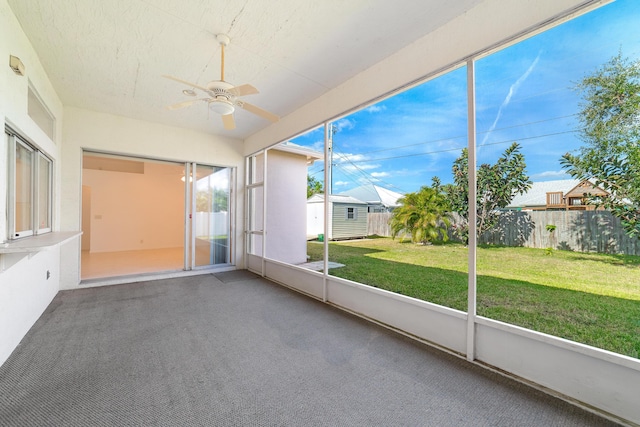 unfurnished sunroom with ceiling fan