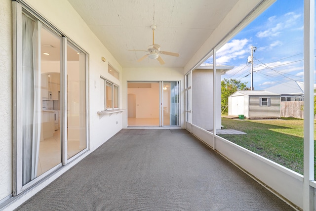 unfurnished sunroom with ceiling fan