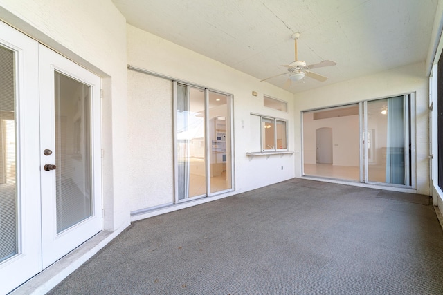 unfurnished sunroom featuring ceiling fan